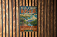 A vintage-style metal sign for Mesilla Valley Bosque State Park, featuring a scenic landscape with a river and mountains.