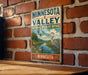 A vintage-style metal sign for the Minnesota Valley National Wildlife Refuge, featuring a scenic illustration of birds and wildlife in the area.