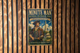 a vintage-style metal sign for Minute Man National Historical Park in Massachusetts, with a depiction of a man in a historical outfit and a gun.
