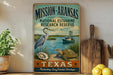 A vintage-style metal sign for the Mission Aransas National Estuarine Research Reserve in Texas, featuring illustrations of a heron, a turtle, and a boat on a body of water.
