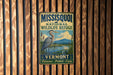 A vintage metal sign for the Missoula National Wildlife Refuge in Vermont, featuring a heron and a lake landscape.