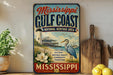 A vintage-style sign for the Mississippi Gulf Coast National Heritage Area, featuring a lighthouse, a bird, and a coastal scene.