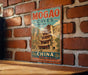 A vintage-style metal sign for the Mogao Caves in China, featuring an illustration of a temple and the text "MOGAO CAVES CHINA".
