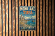 A vintage metal sign for the Mono Lake State Natural Reserve in California, featuring a scenic landscape with mountains, water, and a lake.