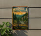 A vintage-style metal sign for Monongahela National Forest, featuring a scenic landscape with pine trees, mountains, and a river.