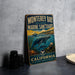 A vintage-style metal sign for Monterey Bay National Marine Sanctuary, featuring an illustration of marine life and the text "California EXPLORE PROTECT INSPIRE".