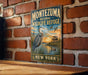 A vintage-style metal sign for the Montezuma National Wildlife Refuge in New York, featuring an illustration of a heron and ducks in a serene landscape with a sunset.