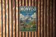 A vintage metal sign with a mountain landscape and a goat, mounted on a wooden wall.