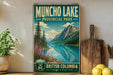 A vintage-style sign for Muncho Lake Provincial Park in British Columbia, Canada, featuring a scenic landscape with mountains, a lake, and pine trees.