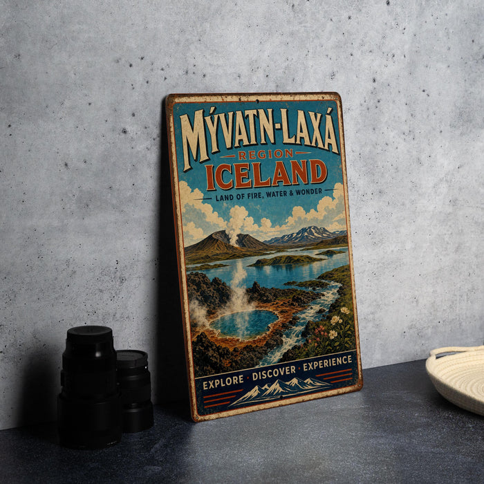 A vintage travel poster advertising Iceland, featuring a scenic landscape with a lake, mountains, and steam vents, is displayed on a wall next to some camera equipment.