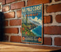 A vintage metal sign for the Na Pali Coast, Hawaii, featuring a scenic mountain landscape with a beach and ocean.