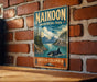 A vintage-style metal sign for NaiKoon Provincial Park in British Columbia, featuring a scenic landscape with a whale in the water.