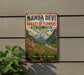 A vintage-style sign advertising the Nanda Devi Valley of Flowers in India, featuring a scenic mountain landscape with colorful flowers.