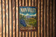 A vintage metal sign with the text "NAPA VALLEY VITICULTURAL LANDSCAPE" and "CALIFORNIA" is displayed on a wooden wall.