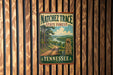 A vintage-style metal sign for the Natchez Trace State Forest in Tennessee, featuring a scenic landscape with a dirt path and a horse.