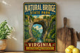A vintage-style metal sign for Natural Bridge State Park in Virginia, featuring a scenic illustration of the natural arch.