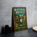 A vintage-style sign for Natural Bridge State Resort Park in Kentucky, featuring a scenic image of the bridge surrounded by lush greenery.