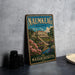 A vintage metal sign for the Naumkeag Estate in Massachusetts, featuring a colorful illustration of the estate surrounded by flowers and a pond.