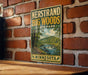A vintage-style metal sign fornersand big woods state park in Minnesota, featuring a scenic landscape with a river and forest.