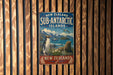 A vintage metal sign advertising the Sub-Antarctic Islands in New Zealand, featuring a penguin and a seal.