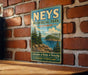 A vintage-style metal sign for Nees Provincial Park, Ontario, featuring a scenic landscape with pine trees, a lake, and mountains.