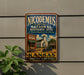 A vintage-style metal sign for the Nicodemus National Historic Site in Kansas, featuring an illustration of a building and a car.