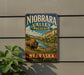 A vintage-style metal sign for Niobrara Valley Preserve in Nebraska, featuring a buffalo in a grassy field with a river and mountains in the background.