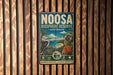 a vintage-style metal sign with a koala and a bird, mounted on a wooden wall.