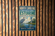 A vintage-style metal sign for the North Carolina Estuarine Research Reserve, featuring a lighthouse and a bird in a grassy area.