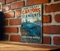 A vintage-style metal sign with the text "NORTHEAST CANYONS AND SEAMOUNTS" and "MARINE NATIONAL MONUMENT" is displayed on a brick wall.