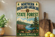 A vintage-style metal sign for the Northern Highland-American State Forest in Wisconsin, featuring a scenic landscape with pine trees, a river, and mountains.