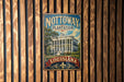 A vintage-style metal sign with the text "NOTTOWAY PLANTATION LOUISIANA" and an illustration of a building, mounted on a wooden wall.