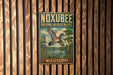A vintage metal sign for the Noxbee National Wildlife Refuge in Mississippi, featuring a colorful illustration of a bird in flight over a pond surrounded by trees.