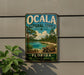A vintage-style metal sign for the Ocala National Forest, featuring a scenic landscape with a turtle in the foreground.