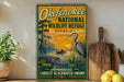 A vintage-style metal sign for the Okefenokee National Wildlife Refuge in Georgia, featuring an illustration of a bird, alligator, and swamp vegetation against a sunset backdrop.