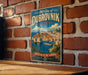 A vintage-style metal sign depicting the city of Dubrovnik, Croatia, with a coastal cityscape and a lighthouse, mounted on a brick wall.