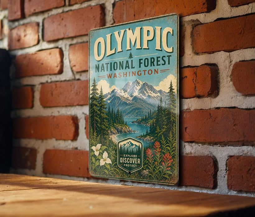A vintage-style metal sign for the Olympic National Forest in Washington, featuring a scenic mountain landscape with pine trees, a lake, and flowers.