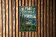 A vintage metal sign for Olympic Peninsula State Forest, featuring a scenic landscape with mountains, pine trees, and a body of water.