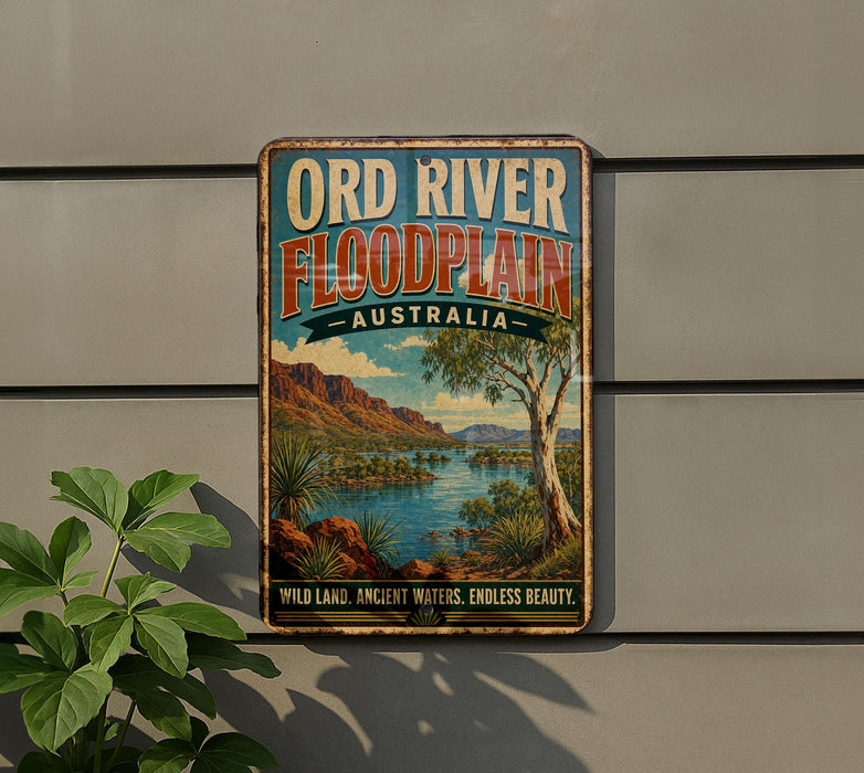 A vintage-style metal sign with the text "ORD RIVER FLOODPLAIN AUSTRALIA" and a scenic image of a river surrounded by mountains and vegetation.