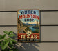 A vintage-style sign advertising the Outer Mountain Loop in Texas, featuring a scenic road surrounded by mountains and a desert landscape.
