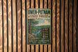 A vintage metal sign for Owen-Putnam State Forest in Indiana, featuring a scenic illustration of the forest and a list of outdoor activities.