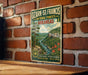 A vintage-style metal sign for Ozark-St. Francis National Forests in Arkansas, featuring a scenic landscape with a river, mountains, and flowers.