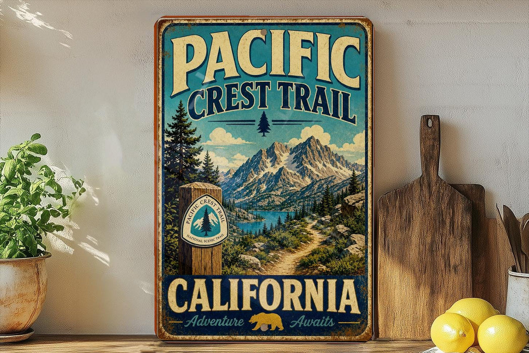 A vintage-style metal sign for the Pacific Crest Trail in California, featuring a scenic mountain landscape and a trail marker.