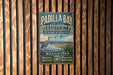 A vintage metal sign for Padilla Bay National Estuarine Research Reserve, featuring a blue background with a white bird and text promoting the reserve's mission to protect and preserve the Washington coast.