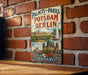 A vintage metal sign displaying the name of a park in Berlin, Germany, with a collage of images depicting the park's architecture and scenery.