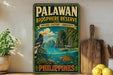 A vintage-style poster of the Palawan Biosphere Reserve in the Philippines, featuring a tropical landscape with a bird, a boat, and a turtle.