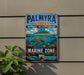 A vintage metal sign for the Palmyra National Wildlife Refuge, featuring a sea turtle and tropical island scenery, is displayed on a wall.