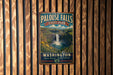 A vintage metal sign for Palouse Falls State Park in Washington, featuring a scenic waterfall and lush greenery.