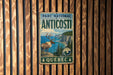 A vintage metal sign for the Park National of Anticosti, featuring a deer and a scenic landscape with cliffs and water.