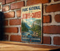 A vintage-style metal sign with the text "PARC NATIONAL de la JACQUES-CARTER" and "QUEBEC-CANADA" is displayed on a brick wall.